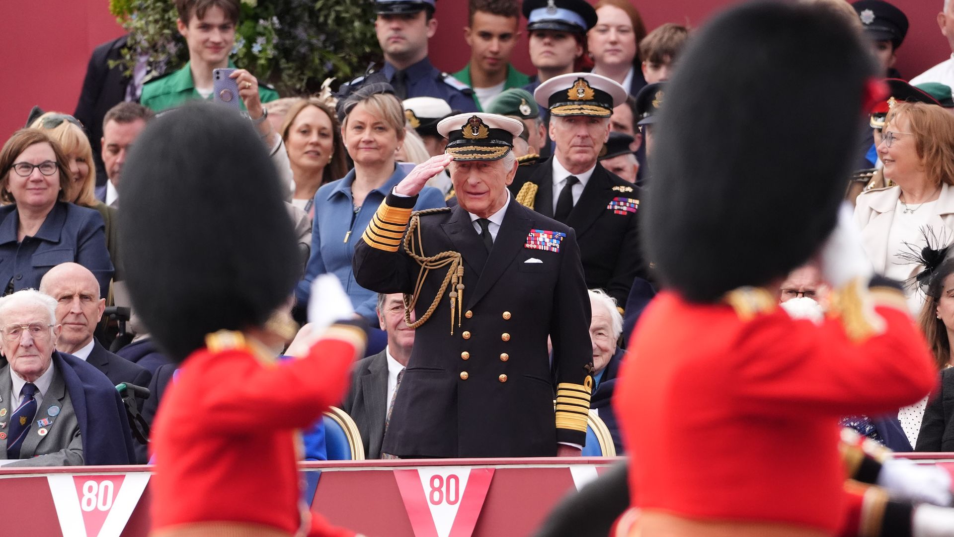 King stands in salute as thousands line streets for VE Day parade